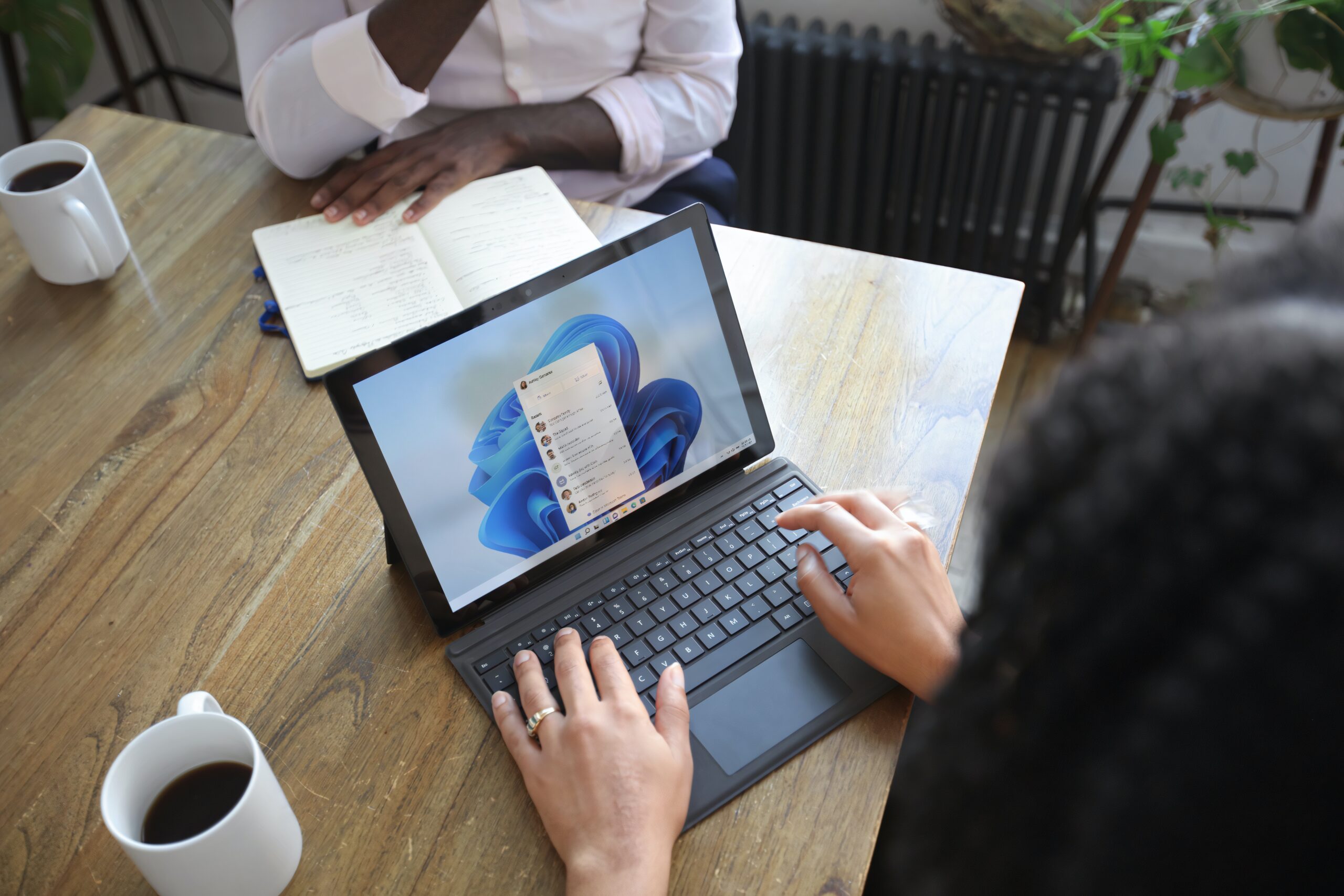 Workspaces-a-VPN-More-Learn-the-Newest-Microsoft-Edge-Features-scaledjpg • Managed IT Services and Cybersecurity Provider in Singapore. Overhead view of two people at a table working with a Microsoft laptop and notebook