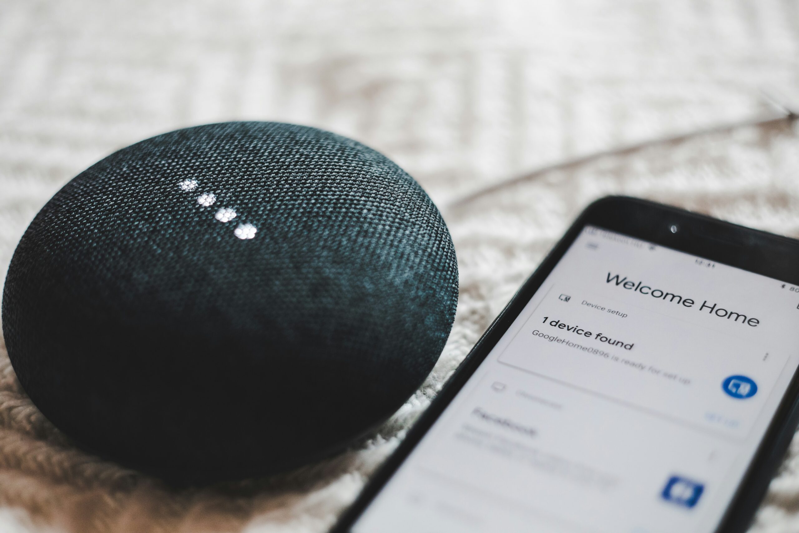 Smart-Tips-for-Building-a-Smart-Home-on-a-Budget-scaledjpg • Managed IT Services and Cybersecurity Provider in Singapore. turned-on charcoal Google Home Mini and smartphone