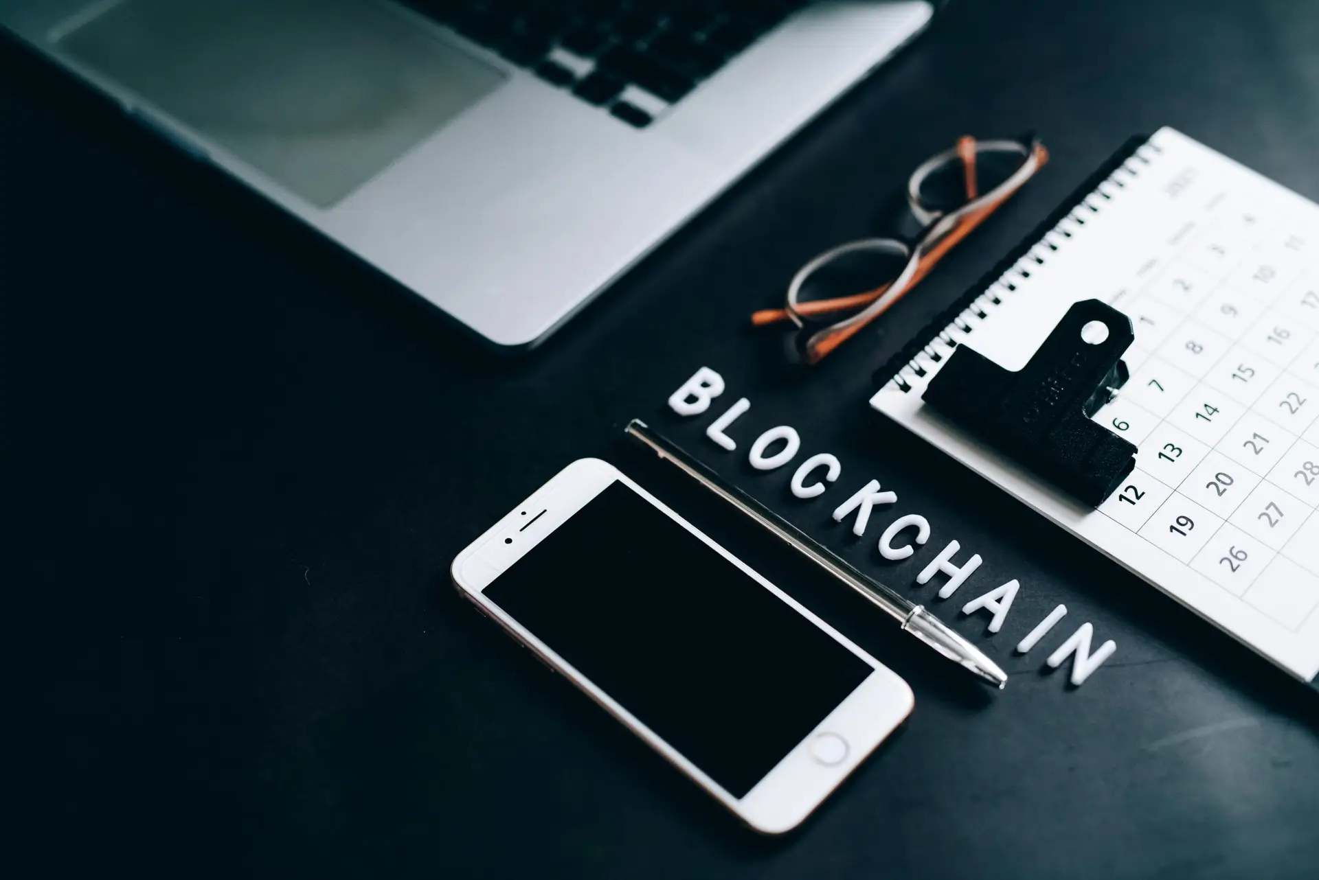 What is Blockchain Technology and How Does it Work scaledjpg • Managed IT Services and Cybersecurity Provider in Singapore. Free Flat lay of a modern digital workspace with blockchain theme, featuring a smartphone and calendar. Stock Photo