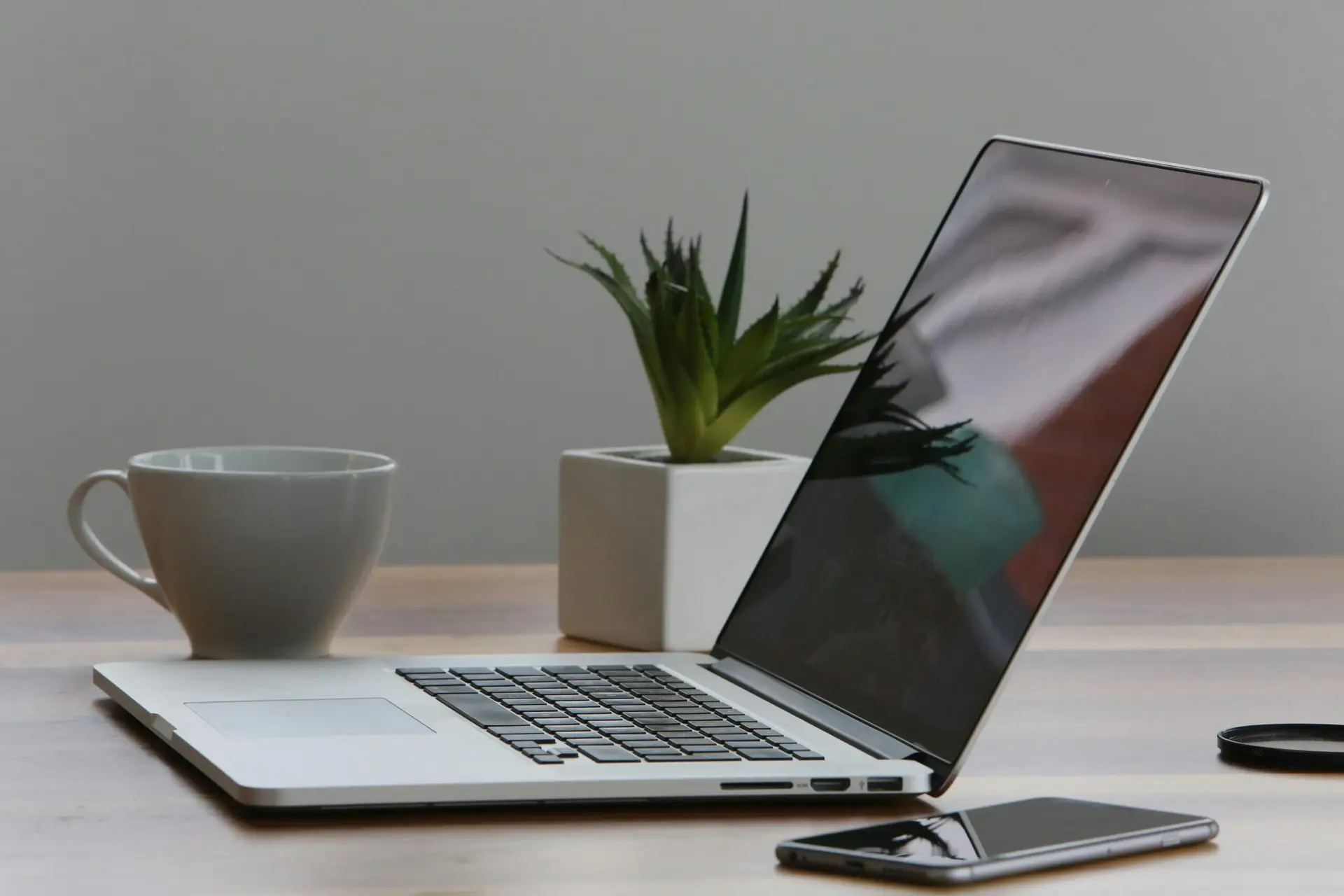 7 Ways Using AI for Work Can Get Complicated scaledjpg • Managed IT Services and Cybersecurity Provider in Singapore. Free Minimalist home office desk with laptop, smartphone, and plant for a modern work environment. Stock Photo