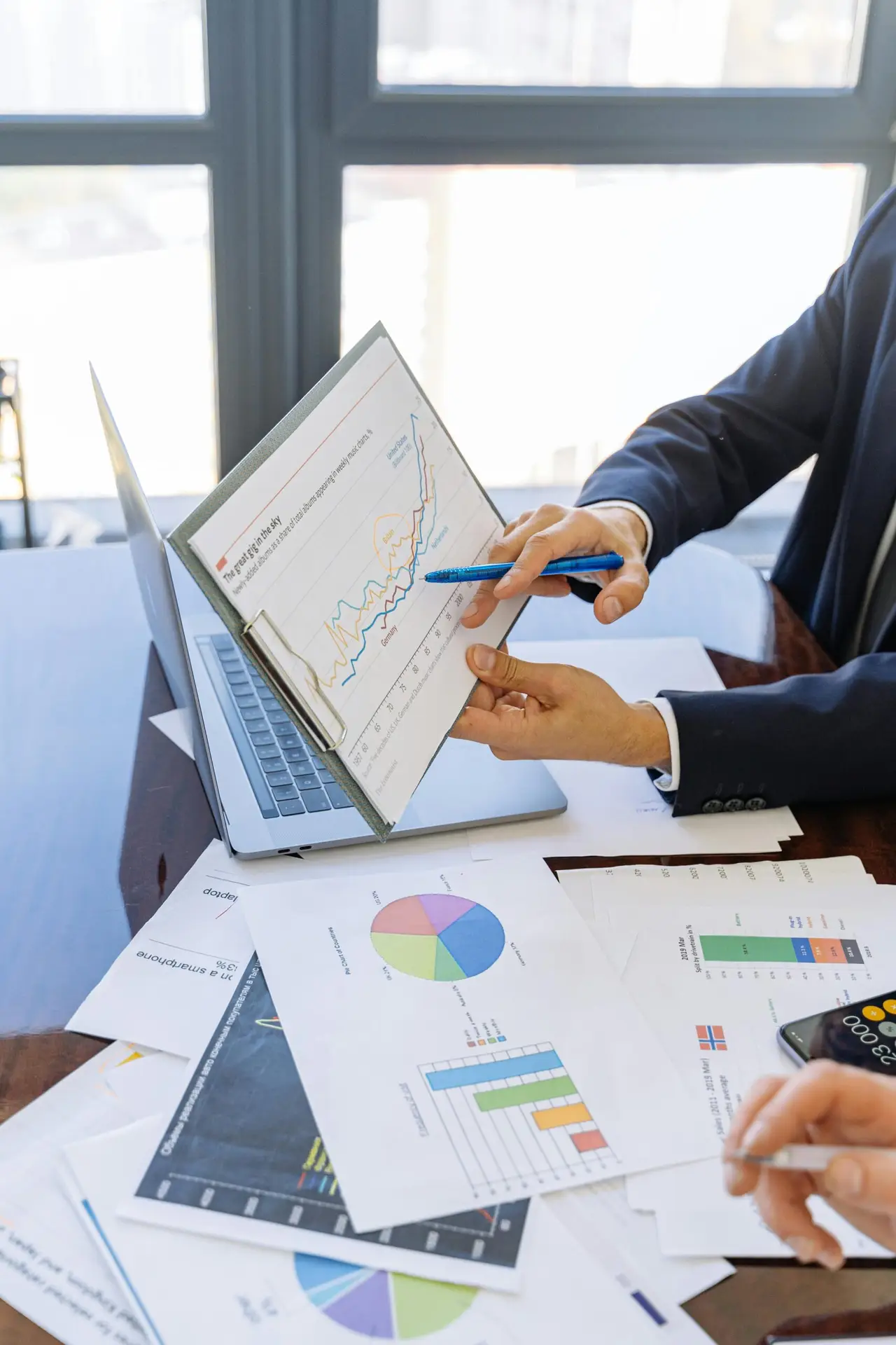 Data-Quality-is-Your-Small-Businesss-Secret-Weapon-scaledjpg • Managed IT Services and Cybersecurity Provider in Singapore. Free Business professionals discussing financial graphs and charts in an office setting. Stock Photo