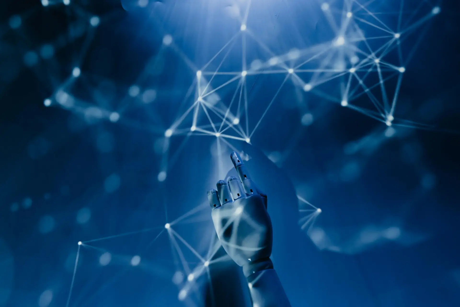 AI-Demystified_-What-to-Know-About-the-Current-Tools-on-the-Market-in-2025-scaledjpg • Managed IT Services and Cybersecurity Provider in Singapore. Free A robotic hand reaching into a digital network on a blue background, symbolizing AI technology. Stock Photo