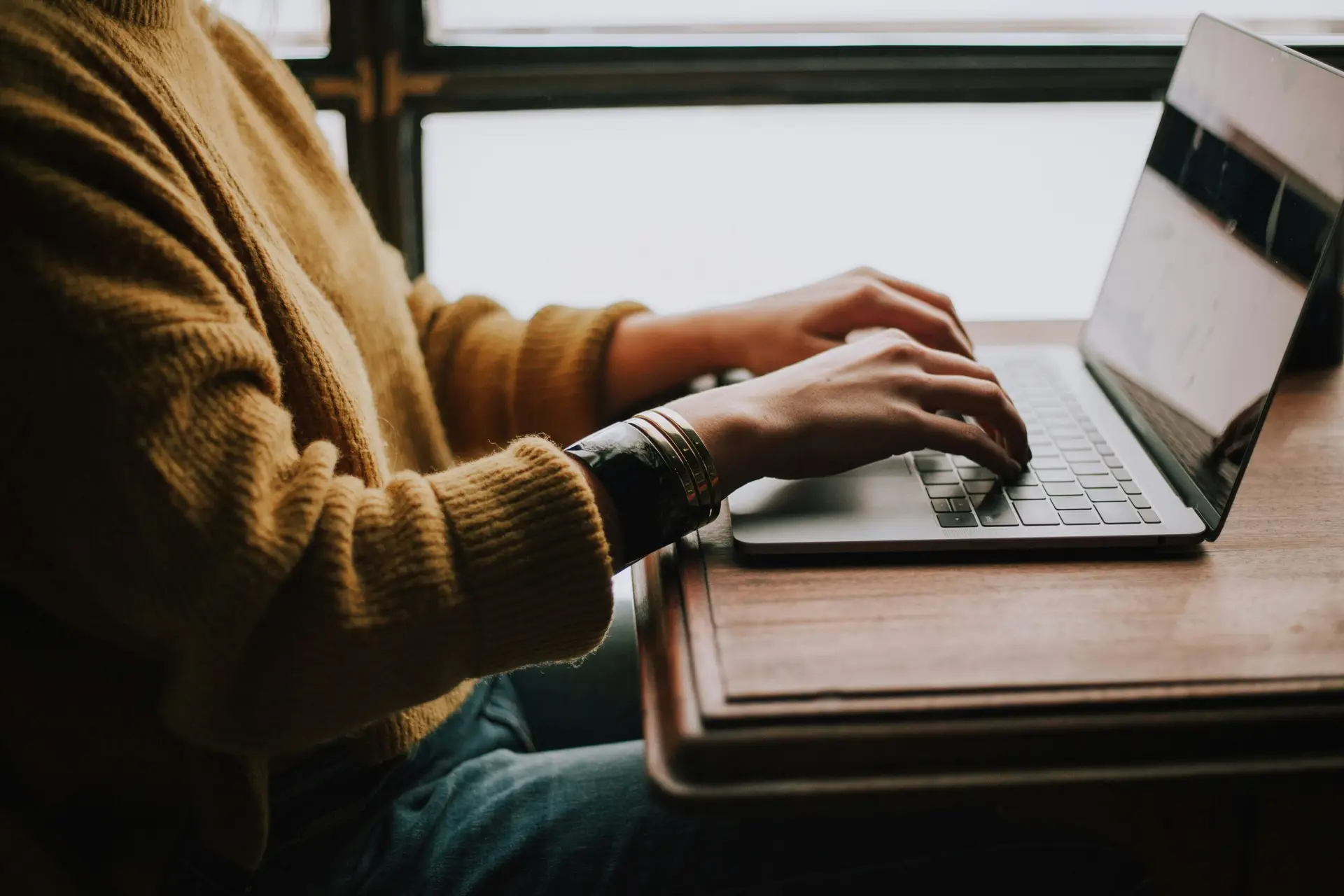 christin-hume-mfB1B1s4sMc-unsplash-scaledjpg | Cybersecurity and Managed Security Services person sitting front of laptop