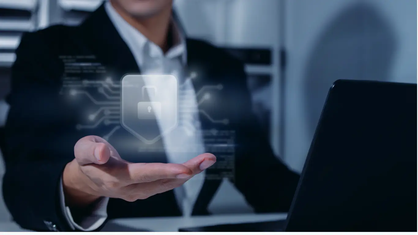 Businessperson in a suit holding out a holographic padlock icon above an open hand, symbolizing cybersecurity.
